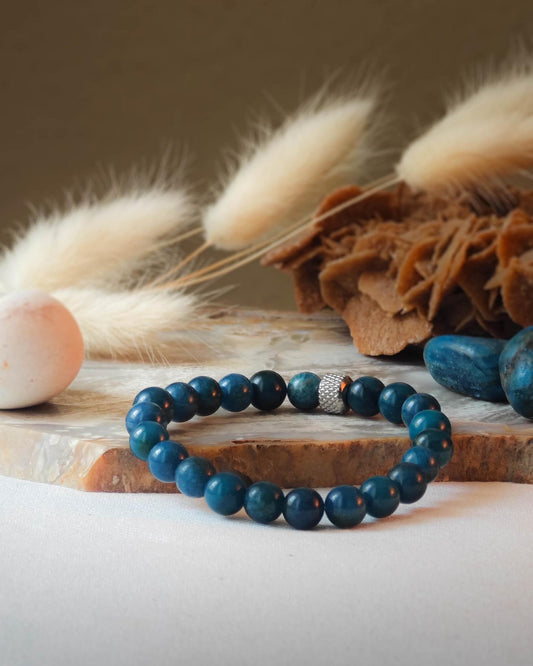 Bracelet en apatite naturel pose sur roche lisse avec epis blancs et pierre polie d apatite