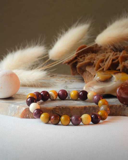 Bracelet en jaspe mokaite naturel pose sur roche lisse avec epis blancs et pierre polie de jaspe mokaite