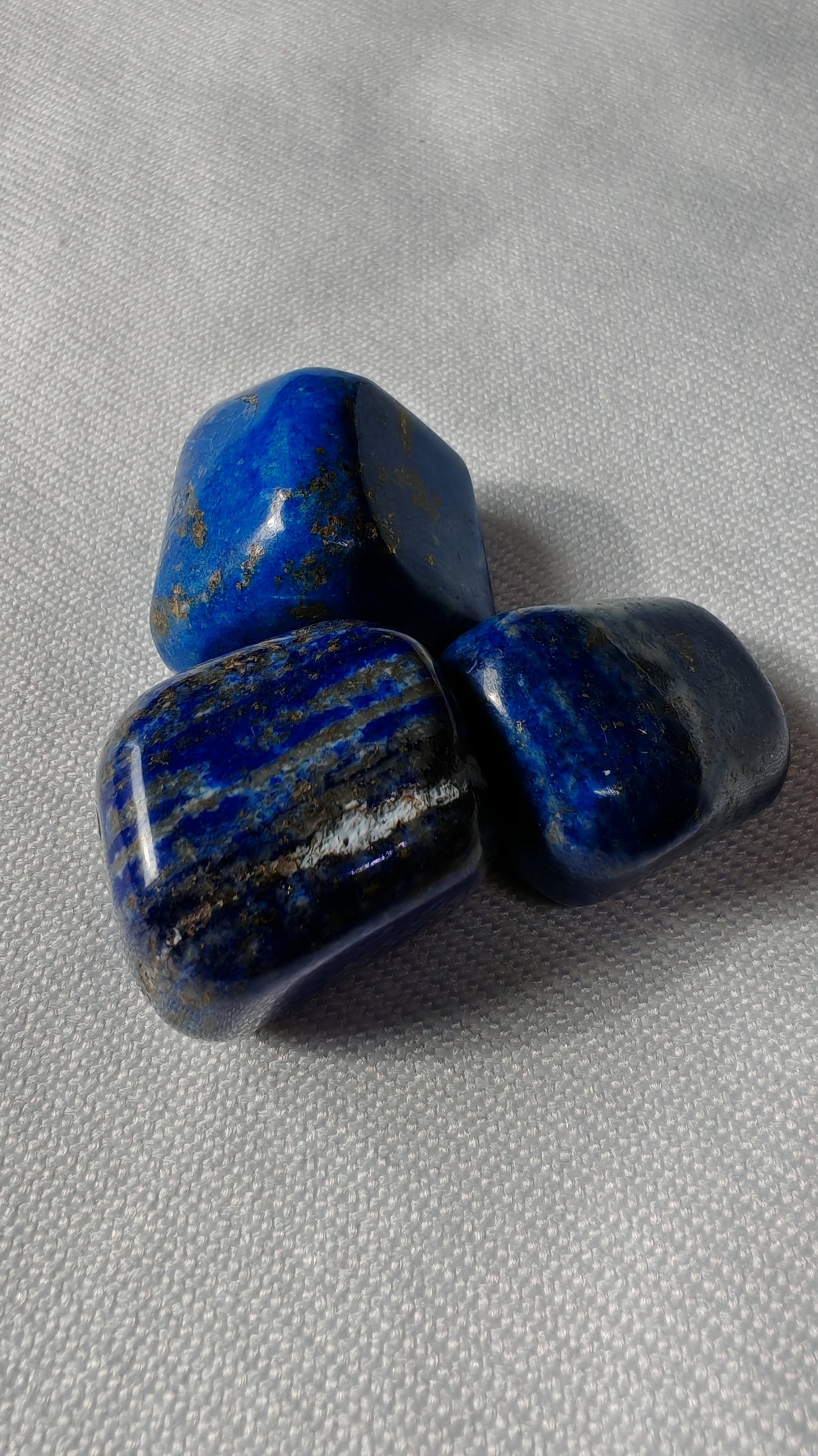 Lapis lazuli pierre roulée sur font blanc