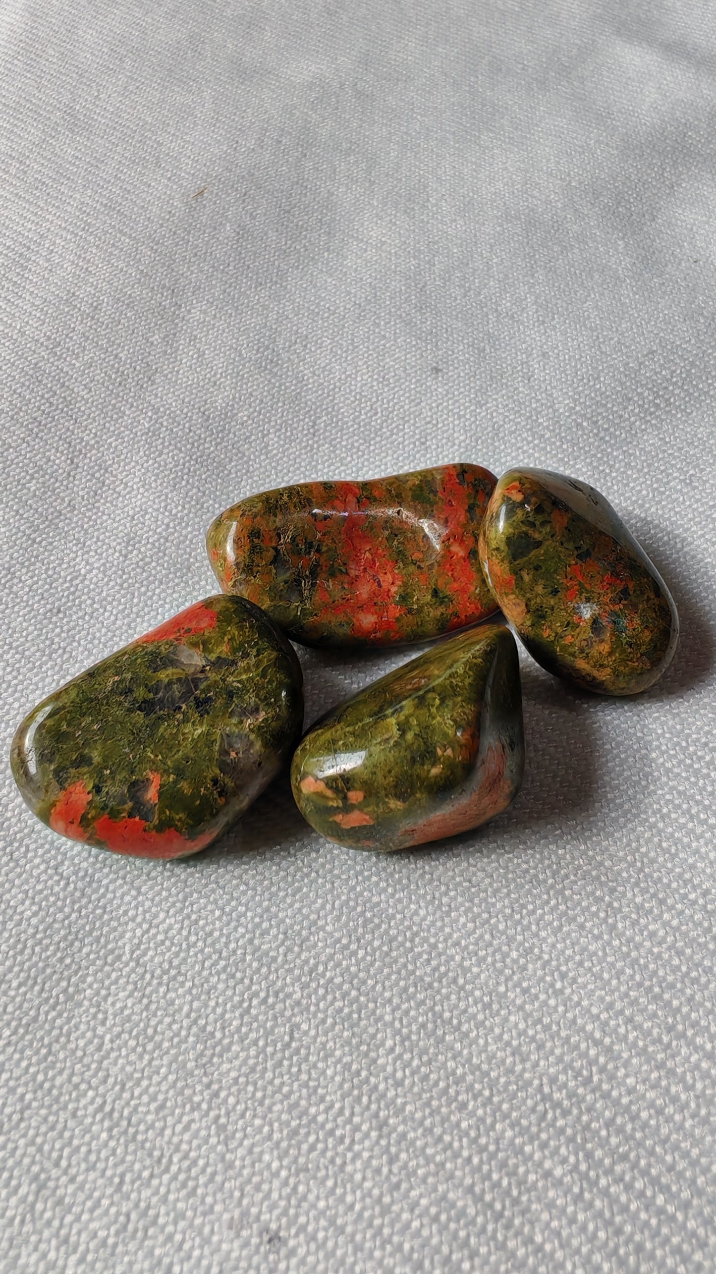 Unakite pierre roulée sur font blanc