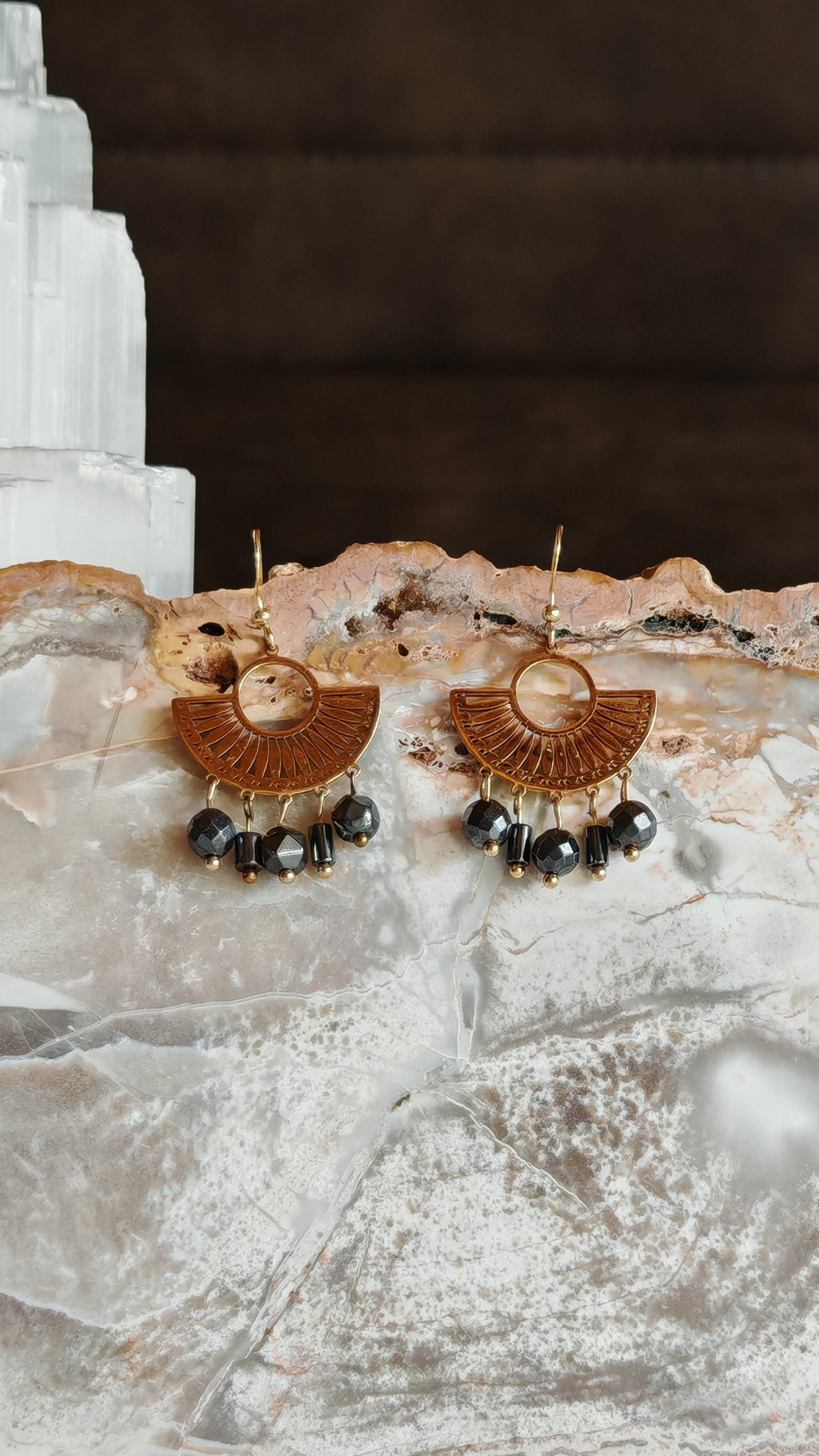 Boucle d'oreilles egyptienne hemtatite posé sur un support en pierre naturelles