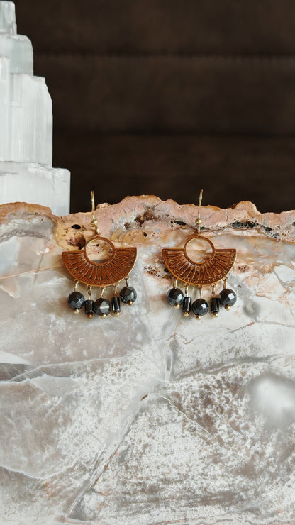 Boucle d'oreilles egyptienne hemtatite posé sur un support en pierre naturelles