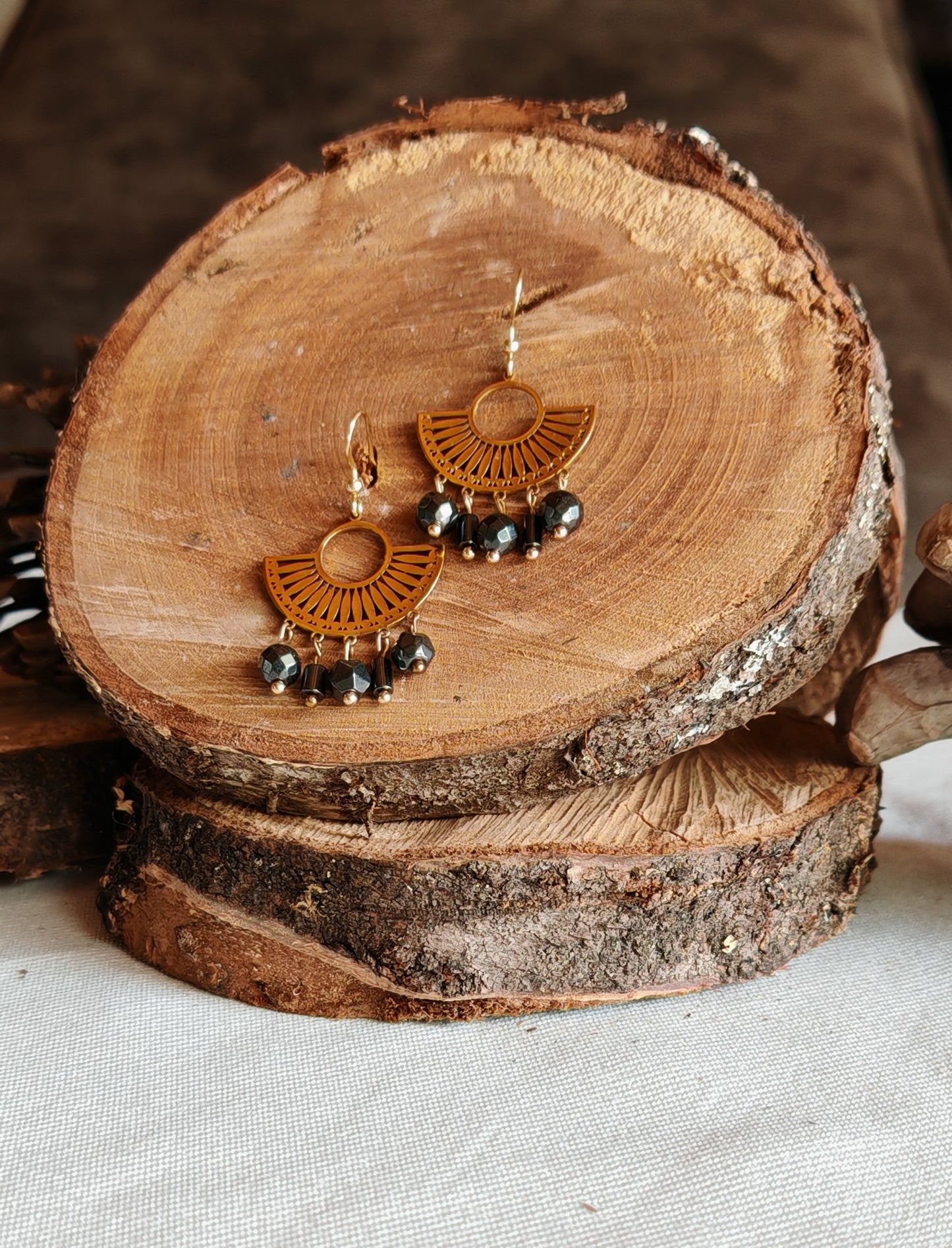 Boucle d'oreilles egyptienne hémtatite posé sur un présentoir en bois