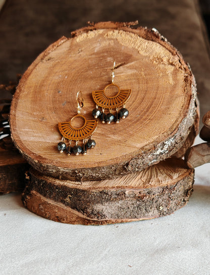 Boucle d'oreilles egyptienne hémtatite posé sur un présentoir en bois