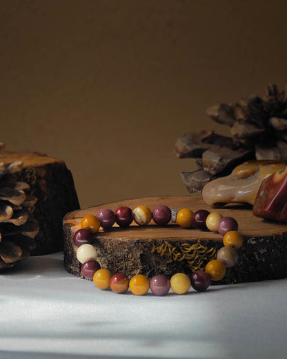 Bracelet en jaspe mokaite naturel pose sur rondelle de bois avec pomme de pin et pierre polie de jaspe mokaite