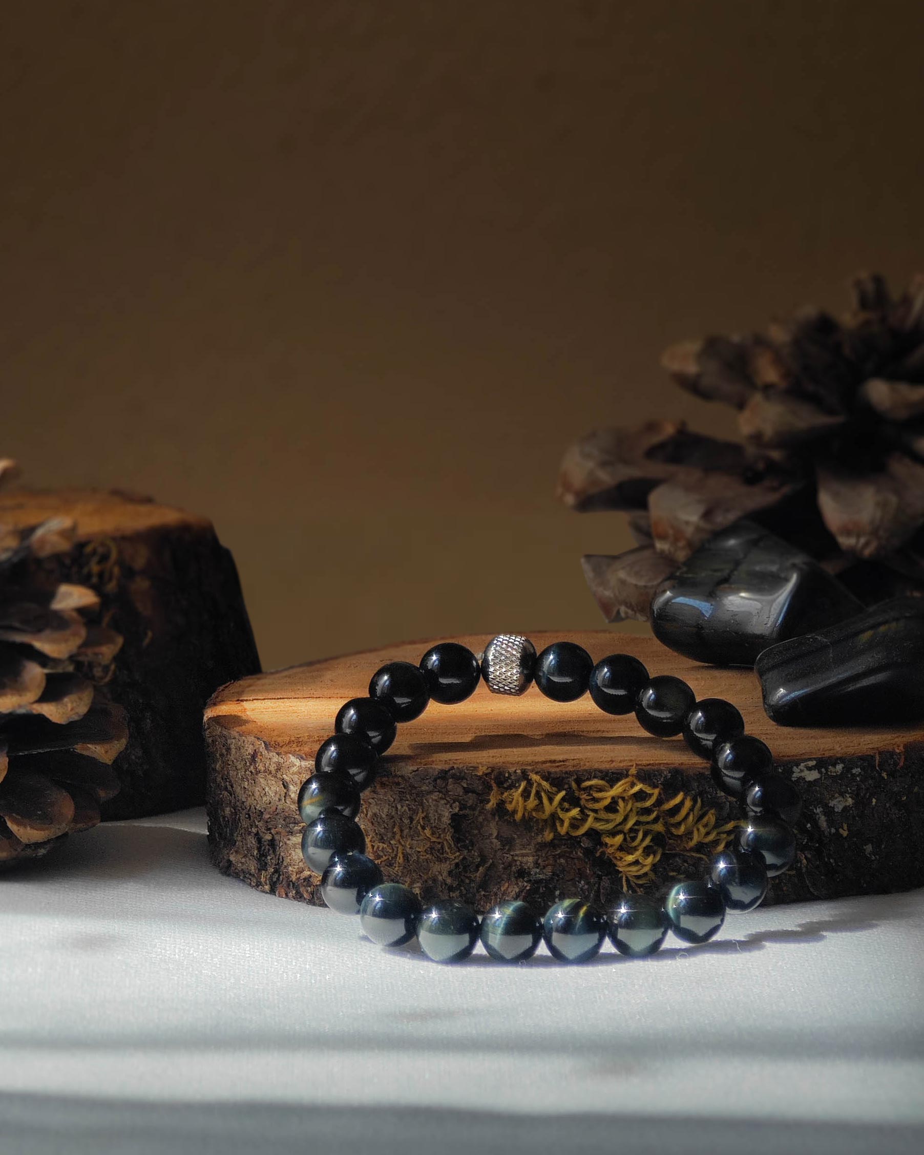 Bracelet en oeil de faucon naturel pose sur rondelle de bois avec pomme de pin et pierre polie d’oeil de faucon