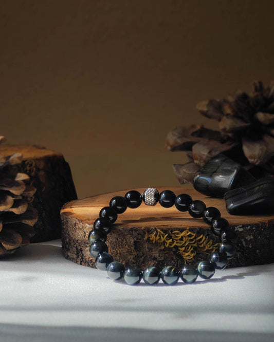 Bracelet en oeil de faucon naturel pose sur rondelle de bois avec pomme de pin et pierre polie d’oeil de faucon