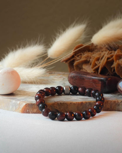 Bracelet en oeil de taureau naturel pose sur roche lisse avec epis blancs et pierre polie d’oeil de taureau