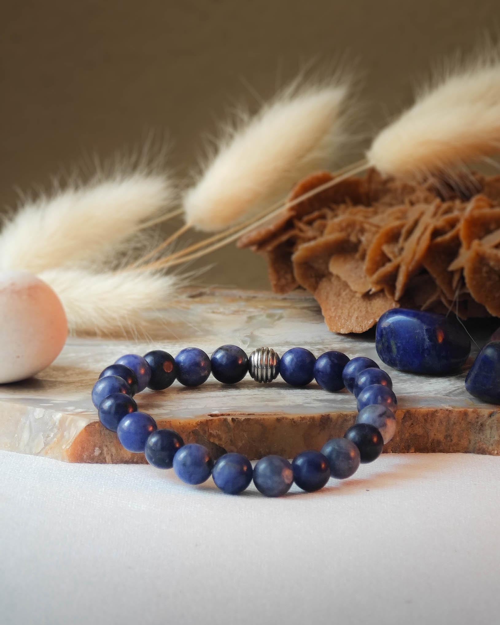Bracelet en sodalite naturelle pose sur roche lisse avec epis blancs et pierre polie de sodalite