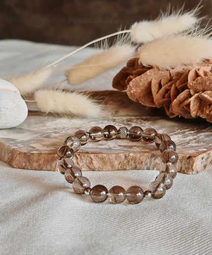 Bracelet quartz fumee sur support en roche blanche