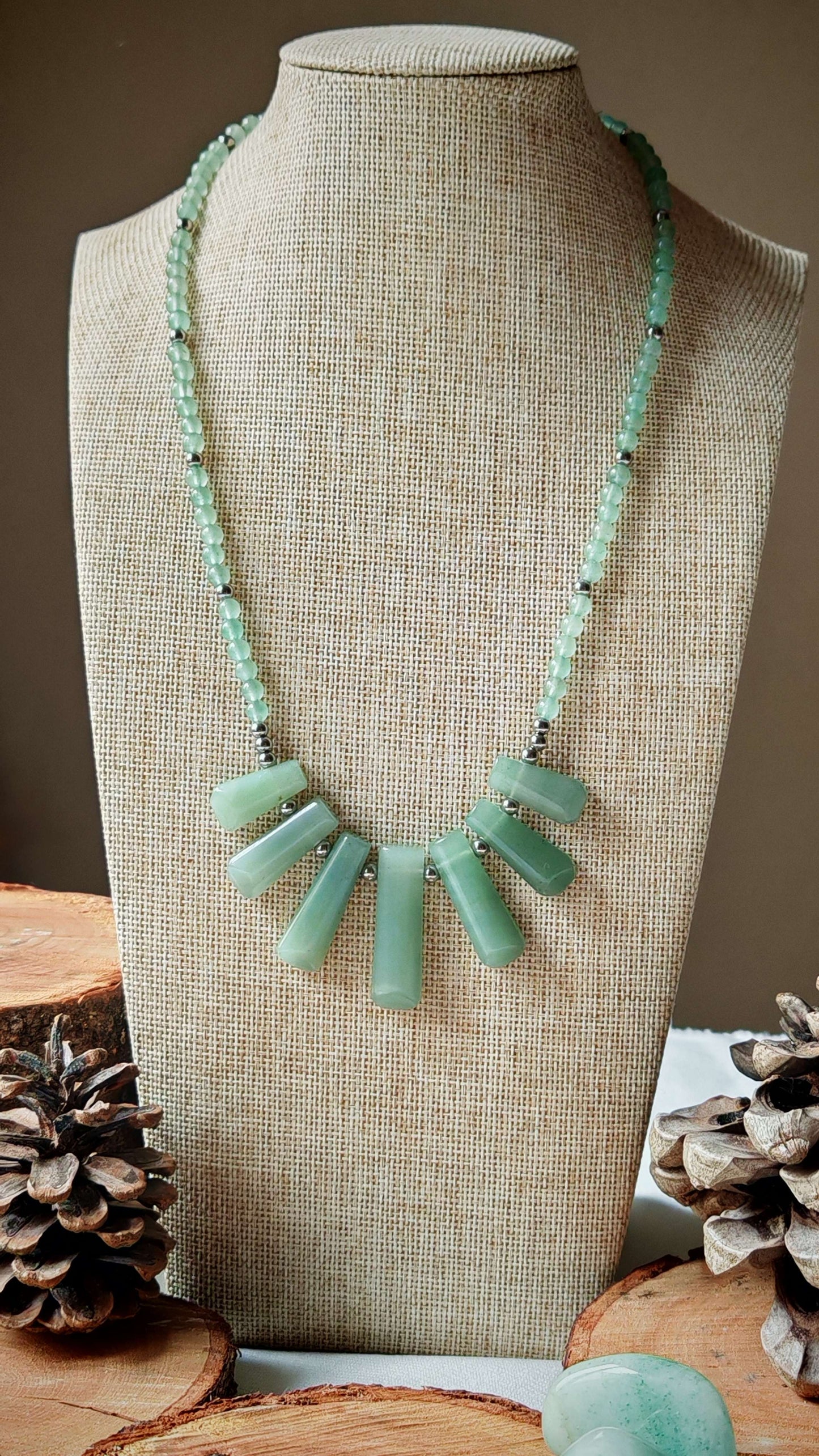 Collier aventurine artemis sur un présentoir avec décord en bois