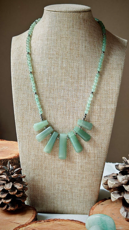Collier aventurine artemis sur un présentoir avec décord en bois