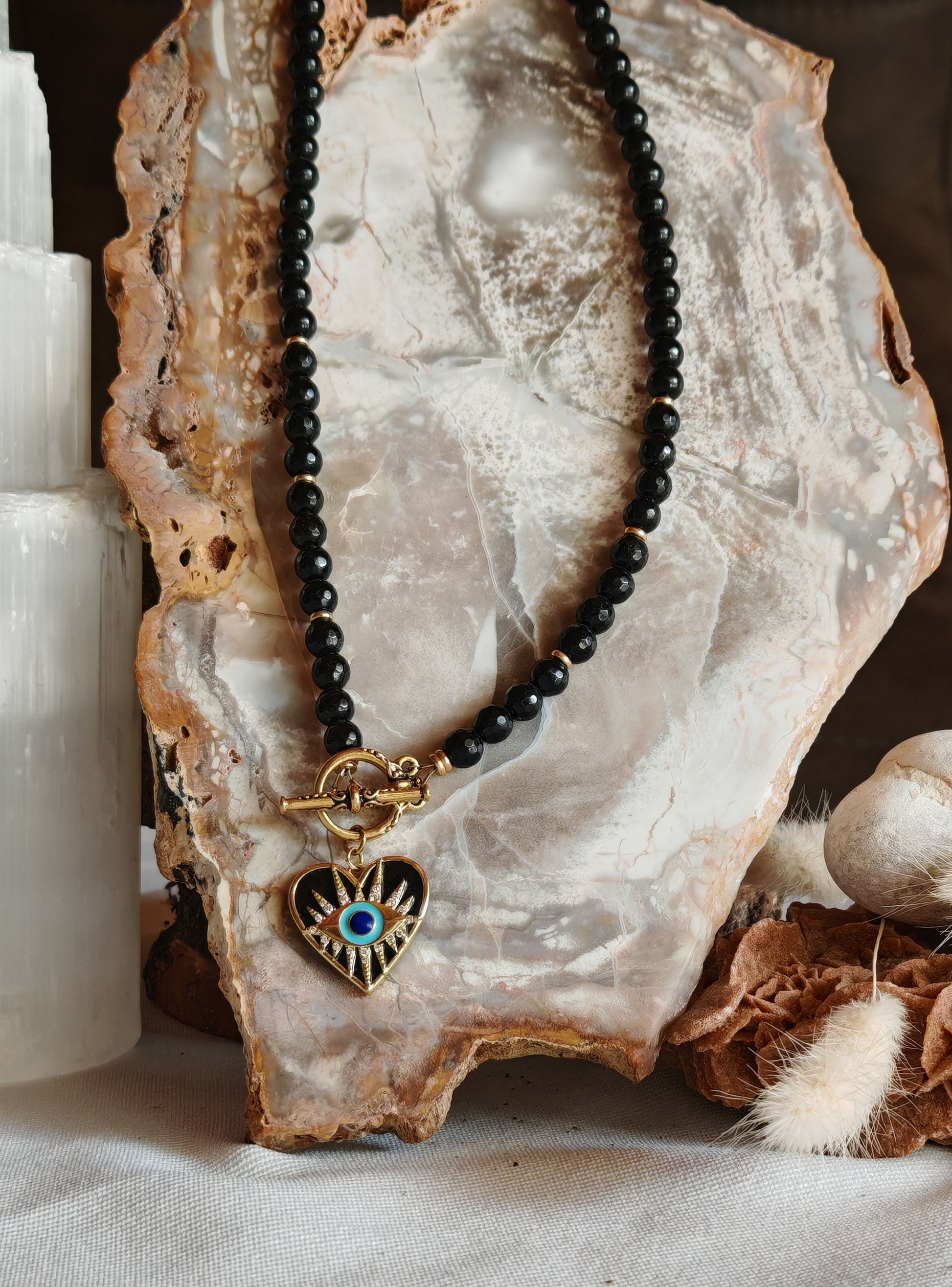 Collier oeil de vision posé sur un présentoir en roche