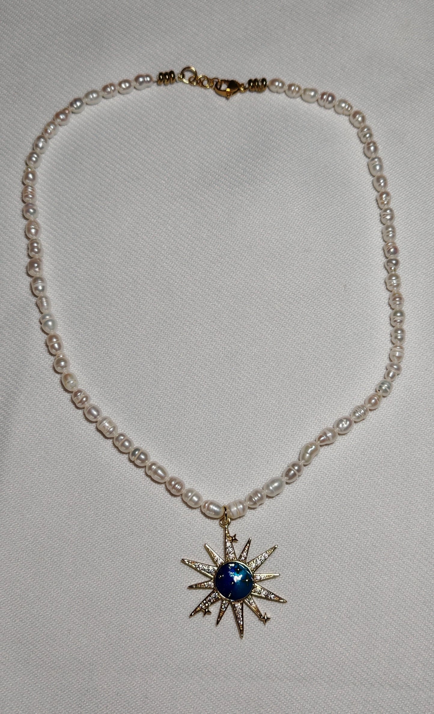 Collier soleil perle deau douce gros plan sur fond blanc