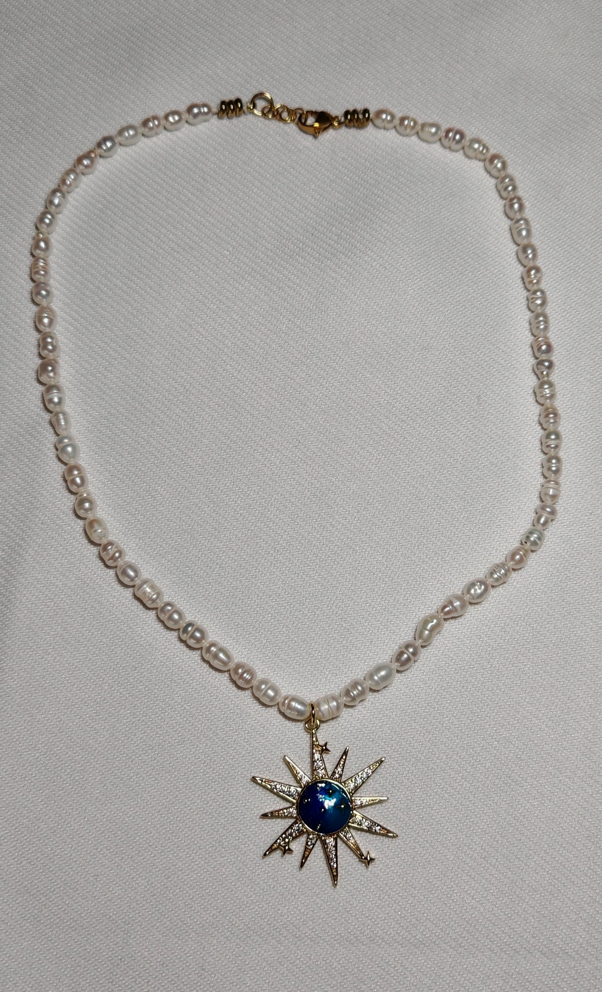 Collier soleil perle deau douce gros plan sur fond blanc