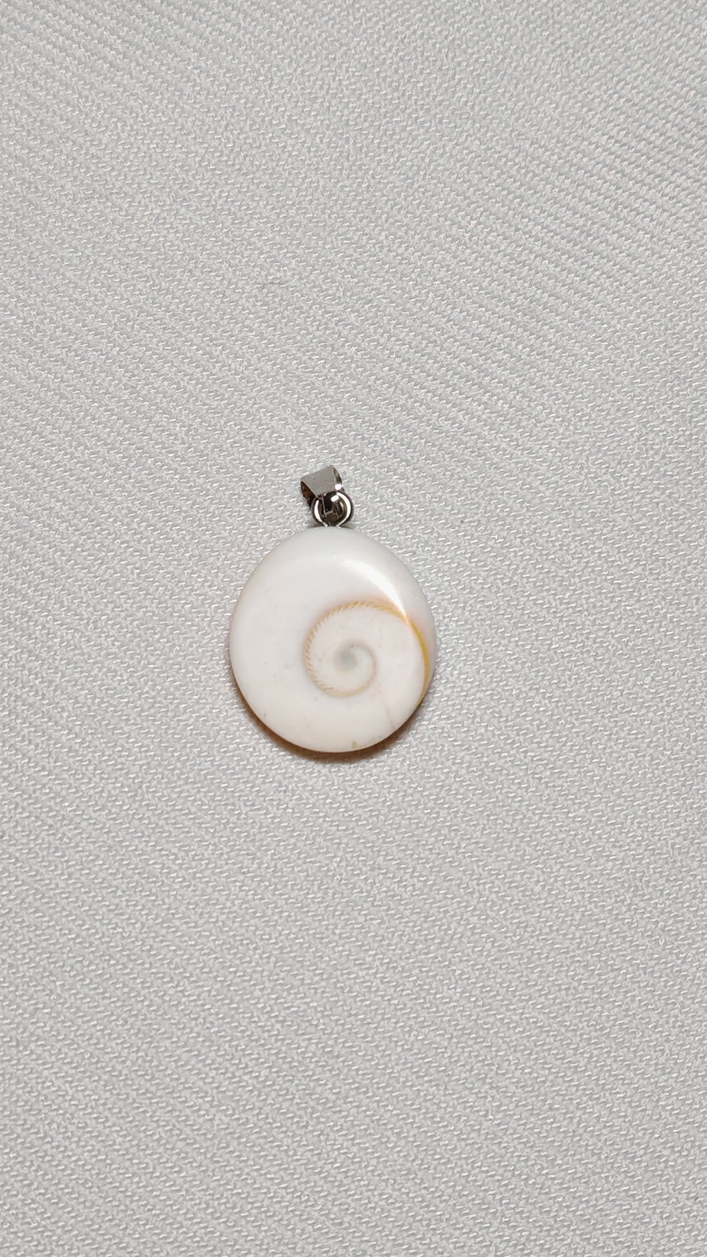 Pendentif en oeil de sainte lucie posé sur lun fond unie blanc