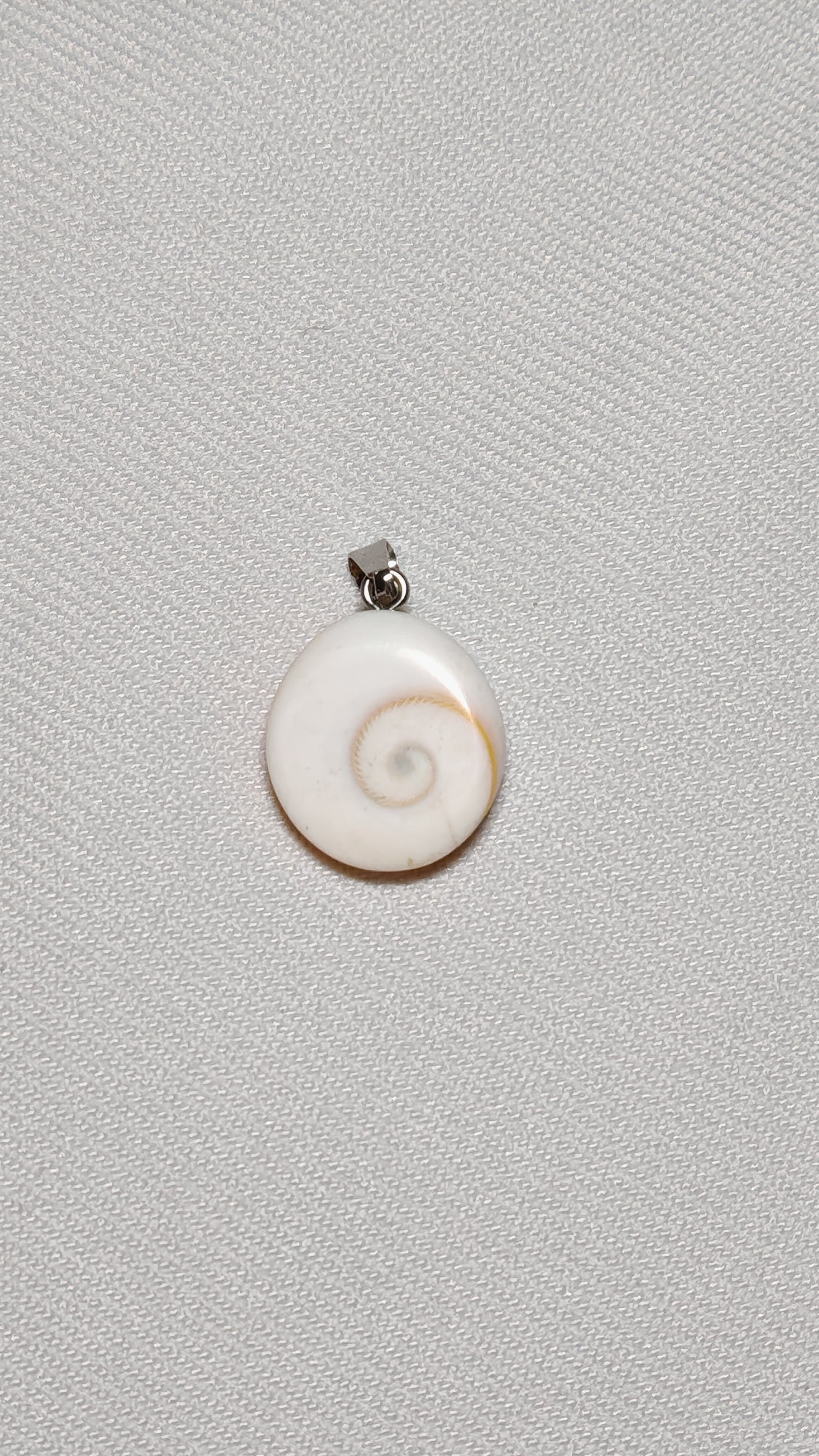 Pendentif en oeil de sainte lucie posé sur lun fond unie blanc