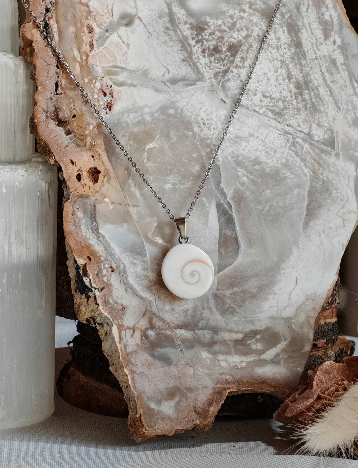 Pendentif en oeil de sainte lucie posé sur une roche blanchatre