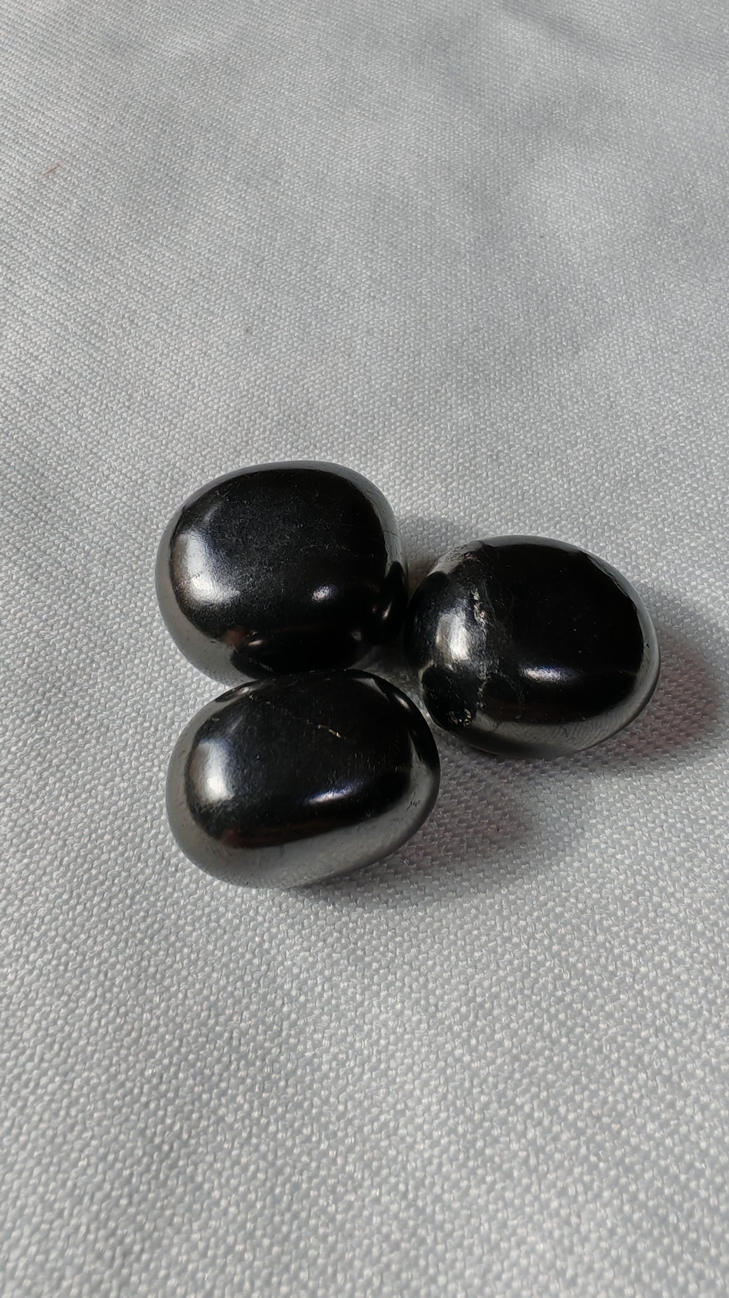 Shungite pierre roulée sur font blanc