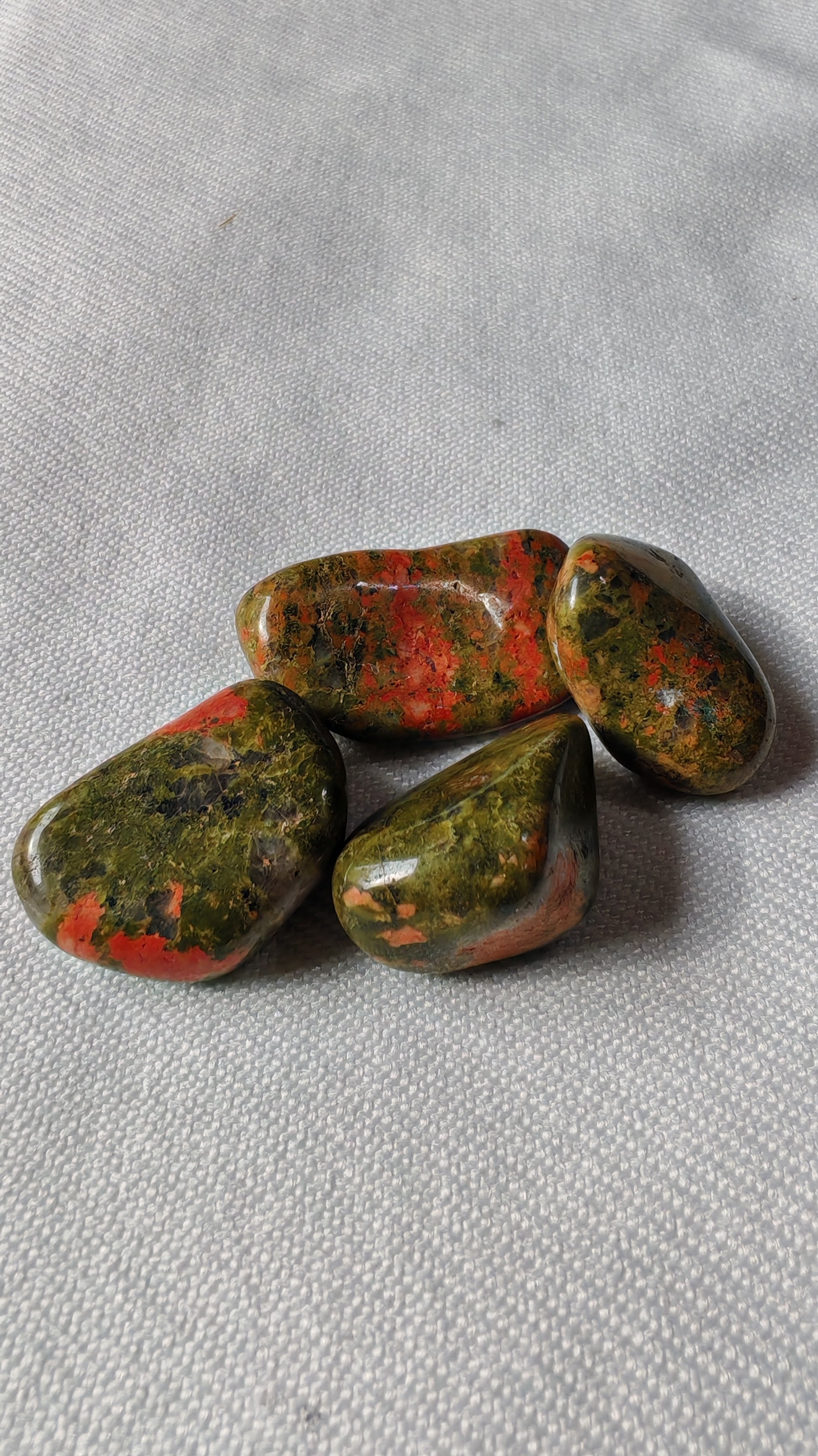 Unakite pierre roulée sur font blanc