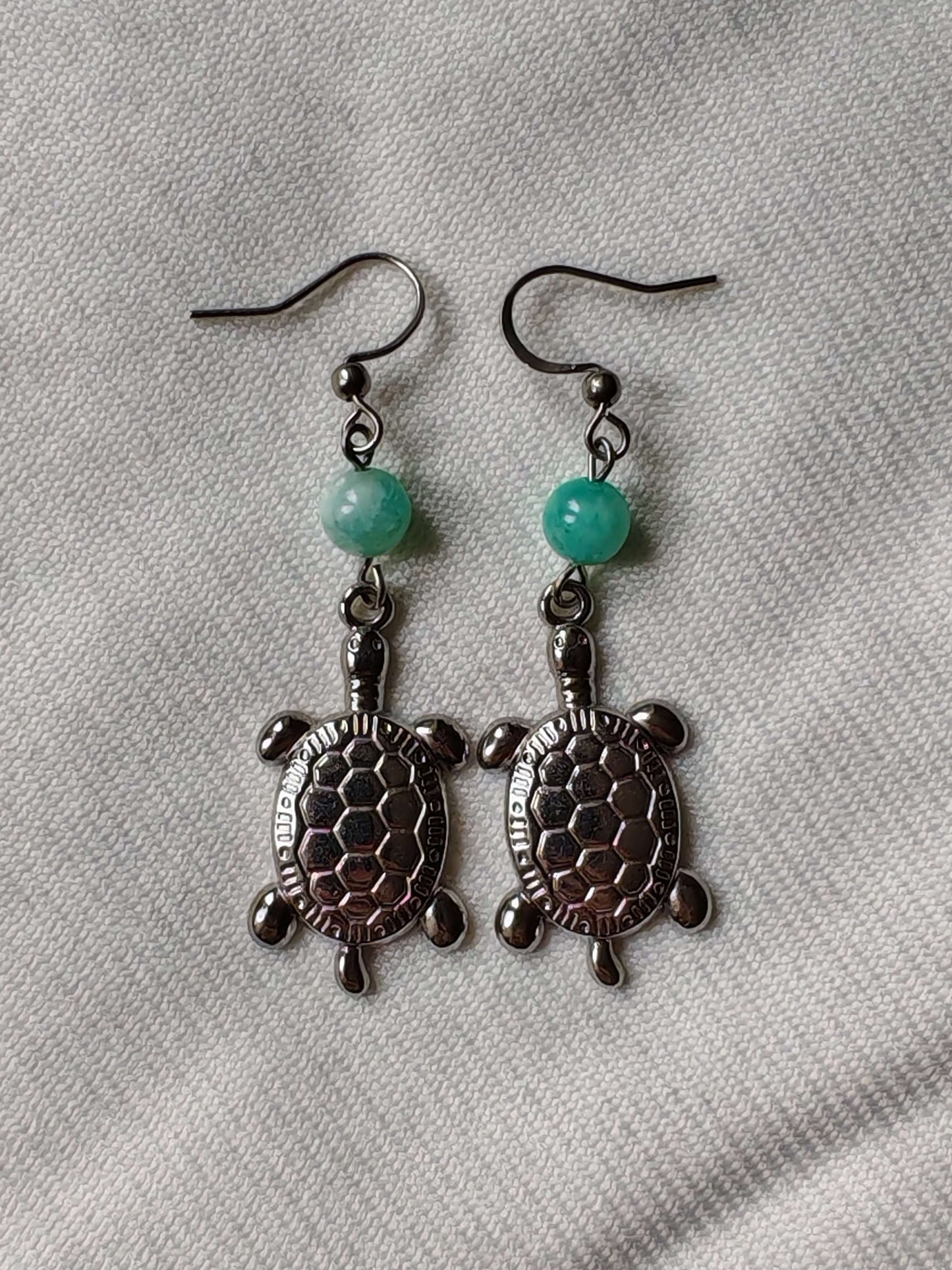boucle d'oreille tortue amazonite sur tissus blanc
