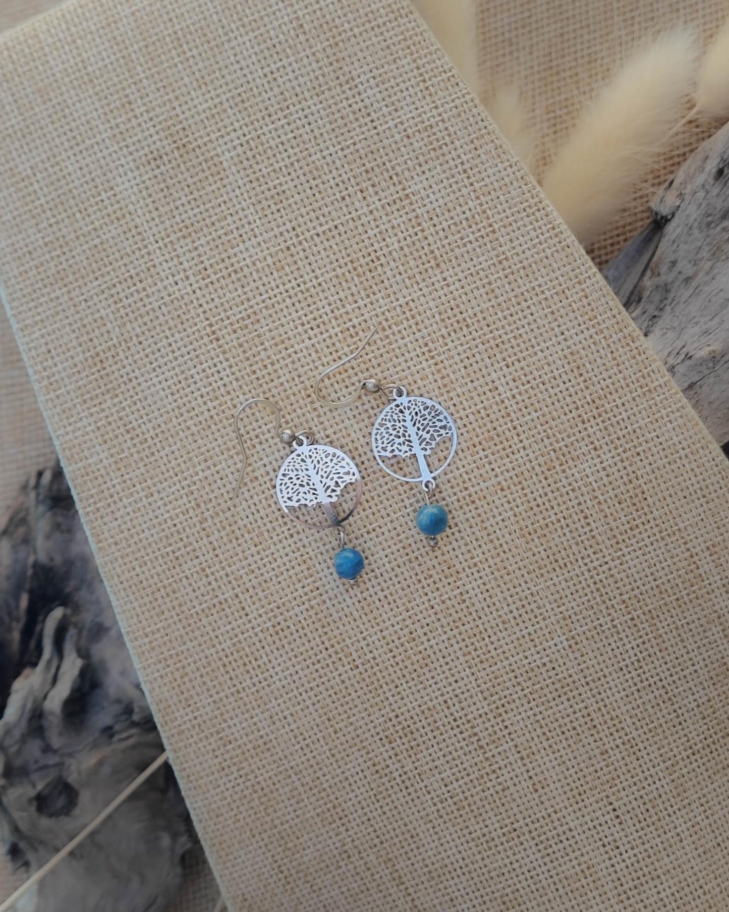 Vue de dessus des boucles d’oreilles Apatite Arbre de Vie en acier montrant détails de la pierre et de l’attache