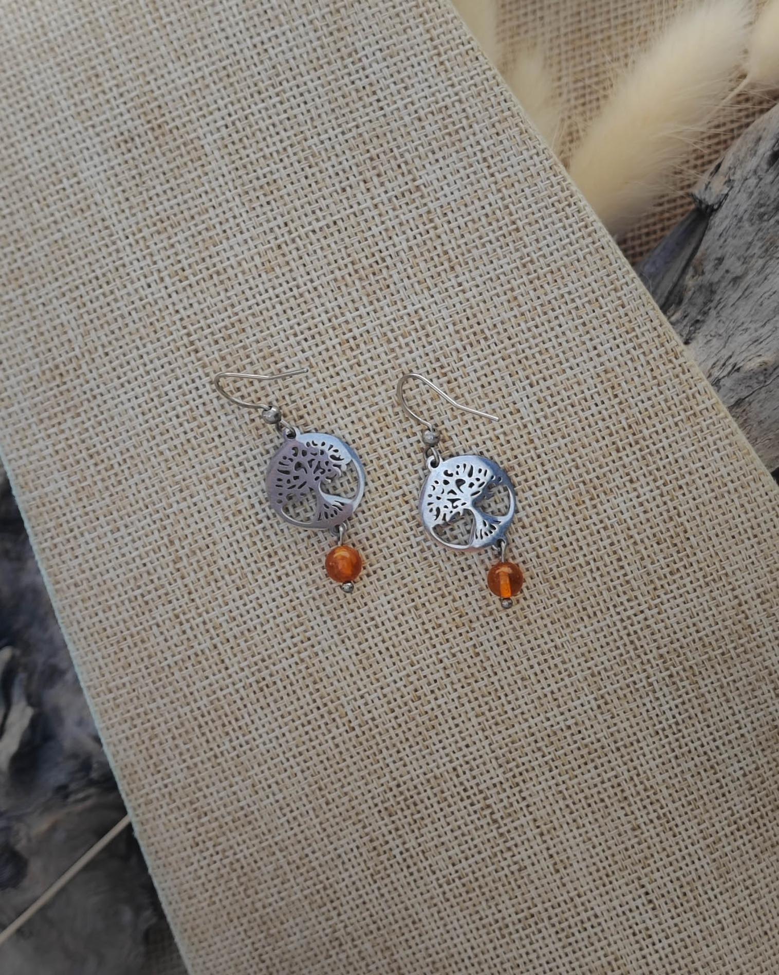 Vue de dessus des boucles d’oreilles Cornaline Arbre de Vie en acier montrant les détails de la pierre et du symbole