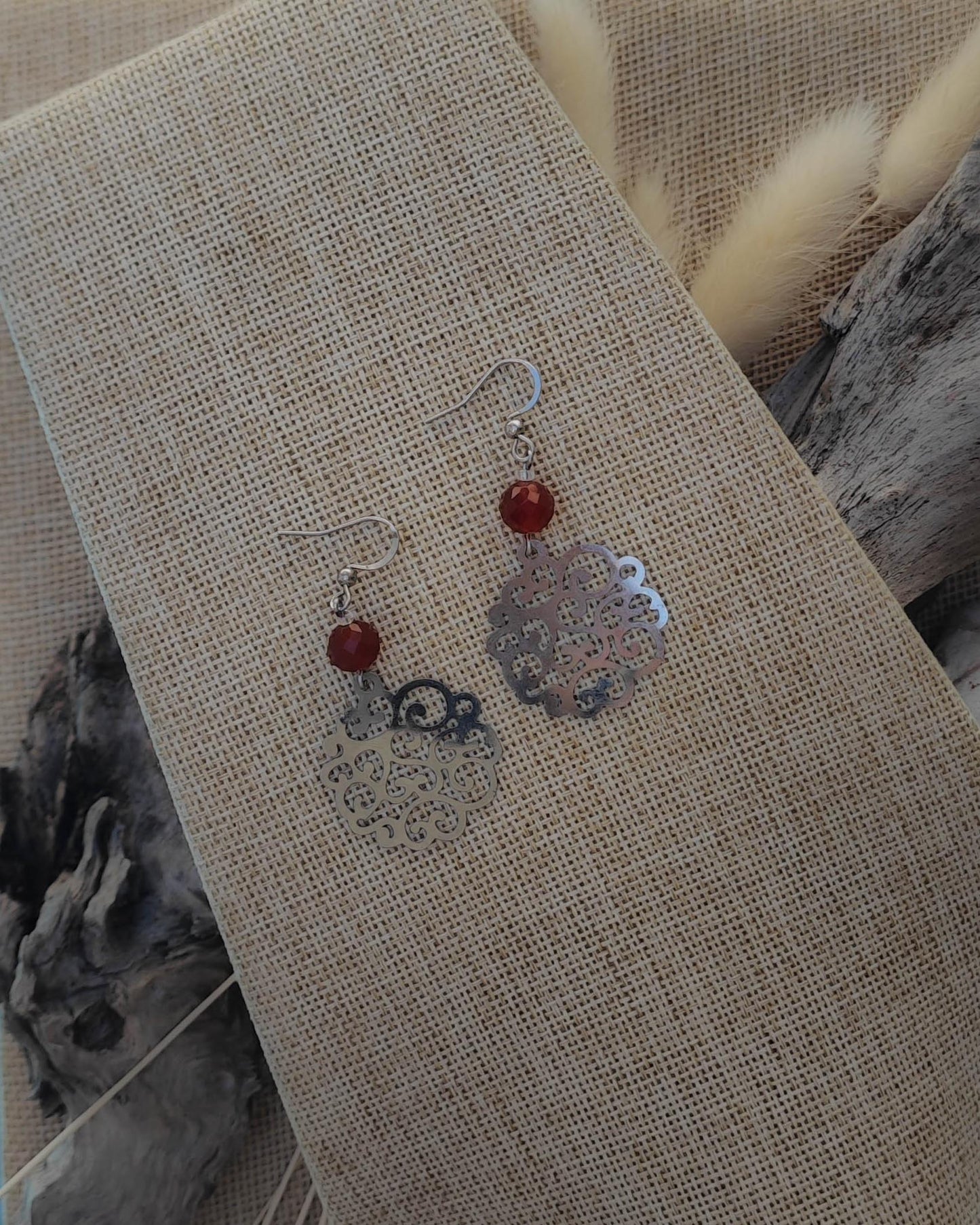 Vue de dessus des boucles d’oreilles Cornaline Filigrane Rosace acier mettant en valeur la pierre et le motif finement travaillé