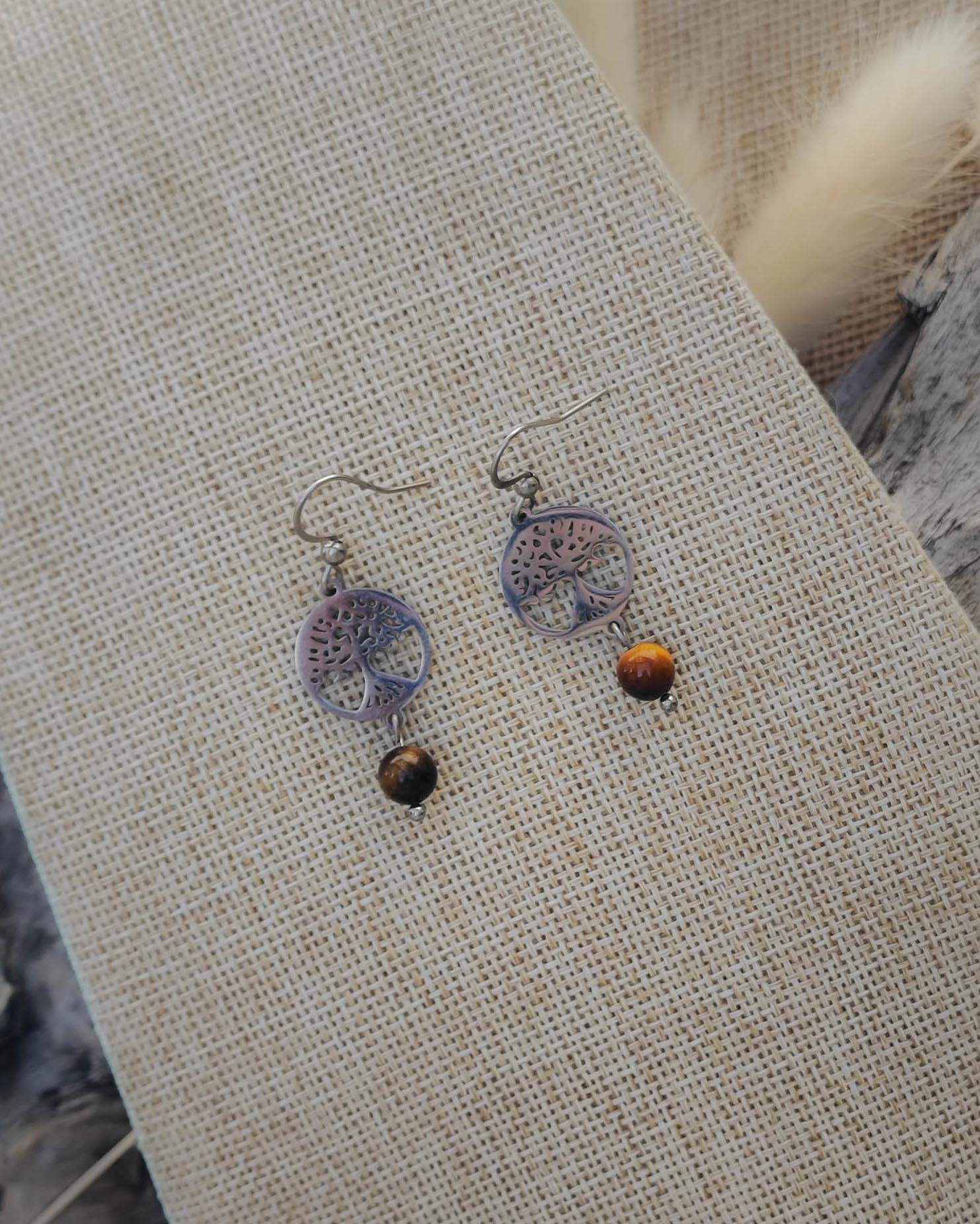 Vue de dessus des boucles d’oreilles Oeil de Tigre motif Arbre de Vie acier mettant en valeur la pierre et le détail du motif