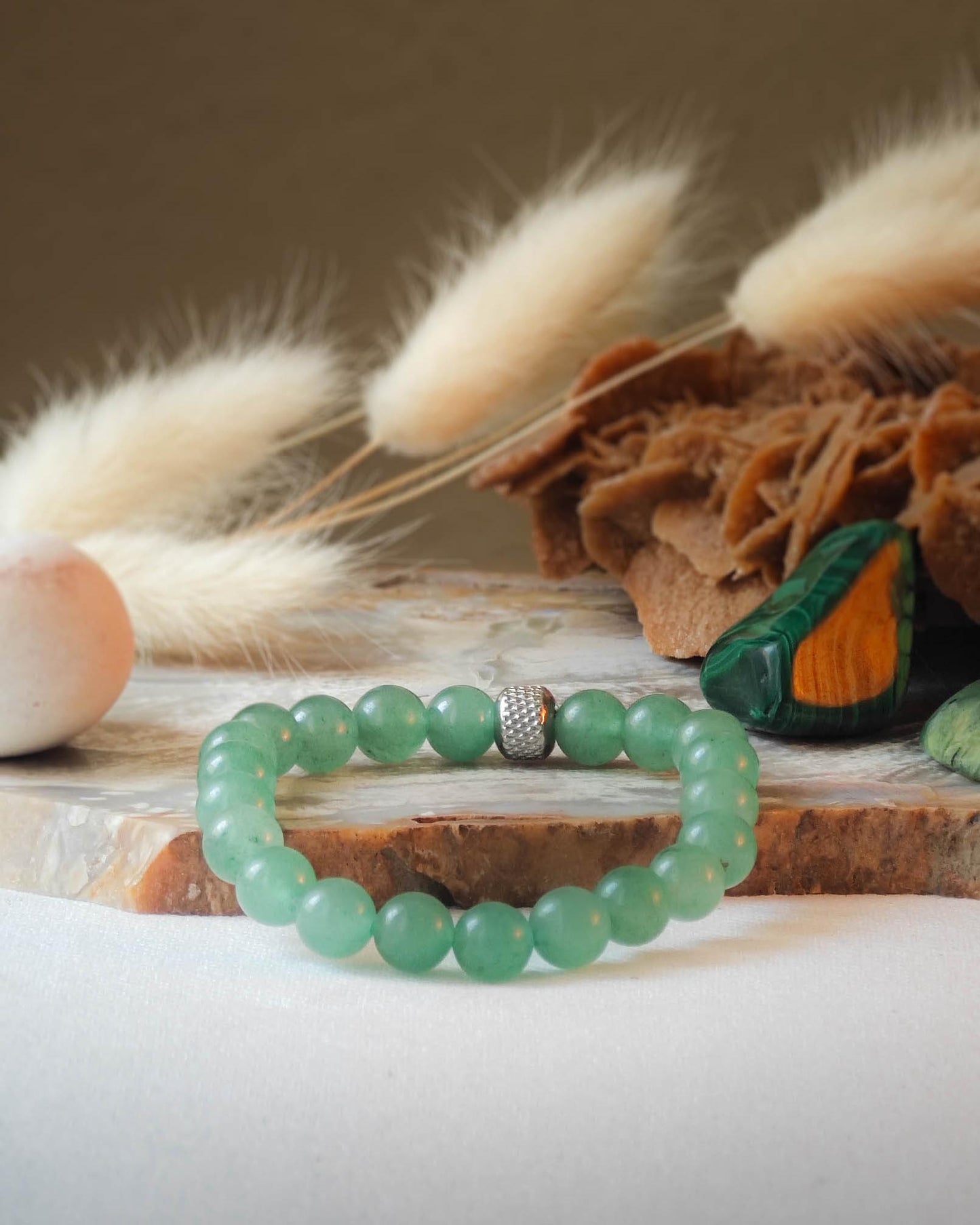 Bracelet en pierre naturelle d'aventurine posé sur une roche