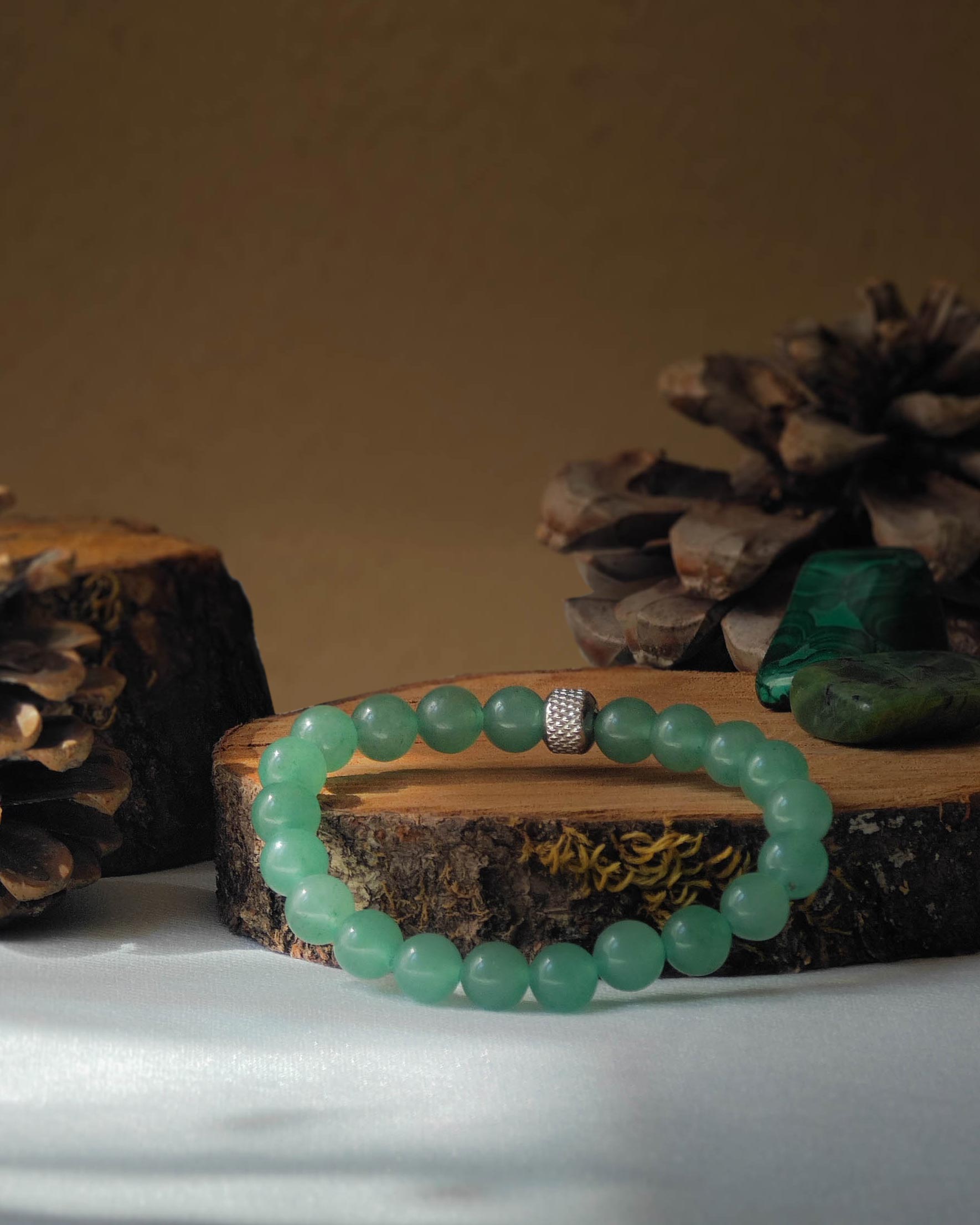 Bracelet ne  pierre naturelle d'aventurine posé sur un bout de bois