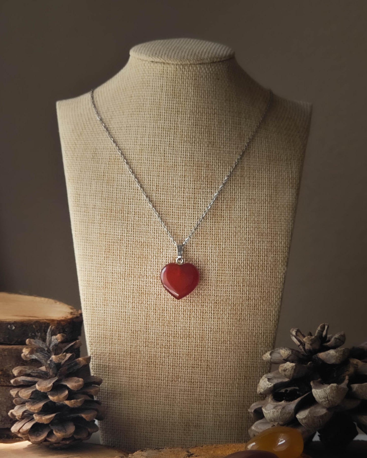 Pendentif Cornaline forme de cœur sur rondelle de bois avec pomme de pin et pierre polie