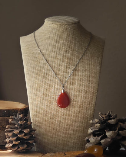 Pendentif Cornaline forme goutte sur rondelle de bois avec pomme de pin et pierre polie