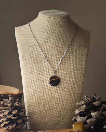 Pendentif OEil de Tigre cercle sur rondelle de bois avec pomme de pin et pierre polie