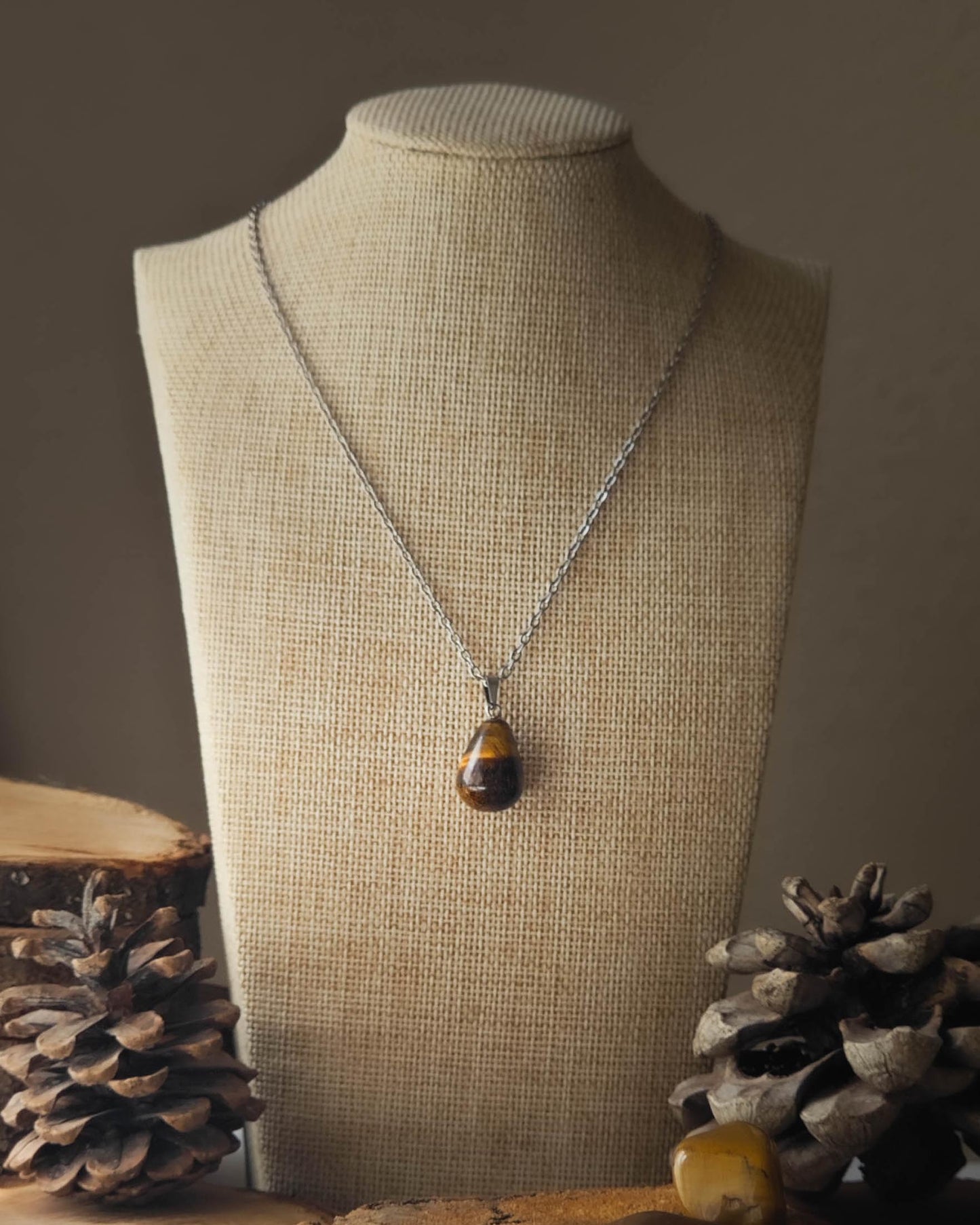 Pendentif OEil de Tigre goutte sur rondelle de bois avec pomme de pin et pierre polie